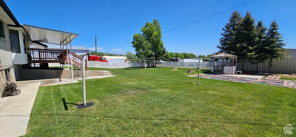 View of yard with a gazebo, a deck, stairs, and a patio