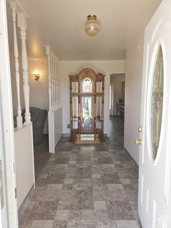 Foyer with dark tile flooring and decorative columns