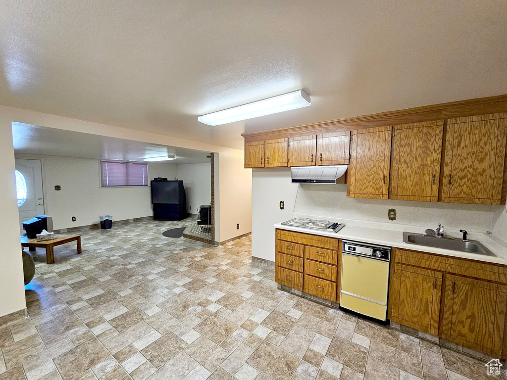 Kitchen with light tile floors, sink, white dishwasher, and gas stovetop