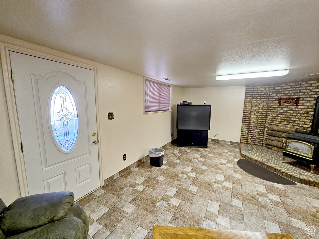 Tiled foyer entrance with a wood stove and a textured ceiling