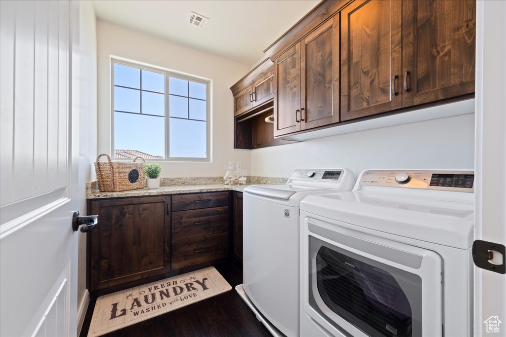 Clothes washing area featuring cabinets, separate washer and dryer, and hardwood / wood-style flooring