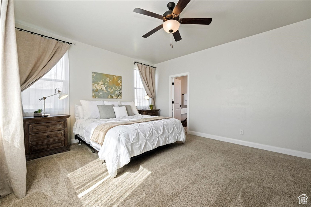Bedroom featuring ceiling fan, carpet, and ensuite bath