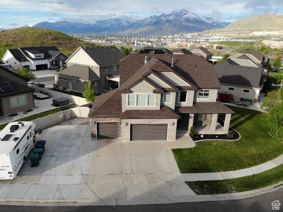 Exterior space with a mountain view, a garage, and a front yard