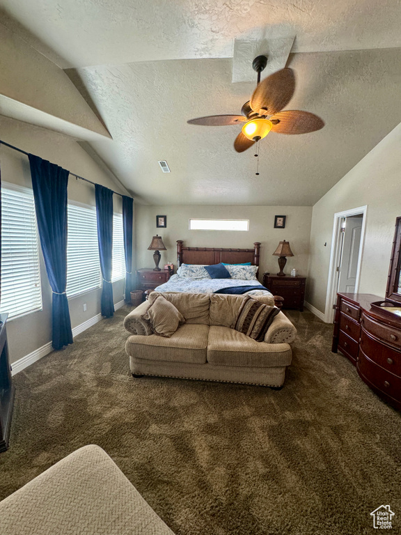 Carpeted bedroom featuring vaulted ceiling, ceiling fan, and a textured ceiling