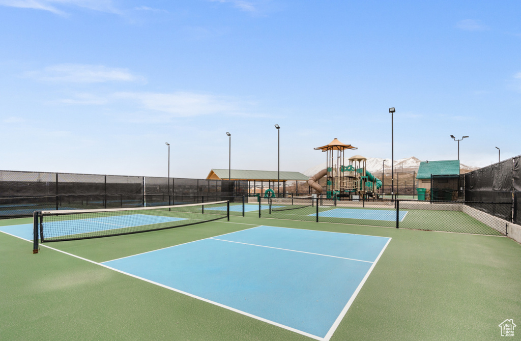 View of tennis court featuring a playground