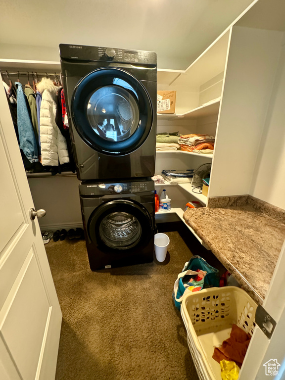 Interior space with stacked washer / dryer and dark colored carpet