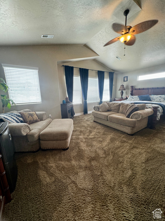 Bedroom with a textured ceiling, ceiling fan, carpet flooring, and vaulted ceiling