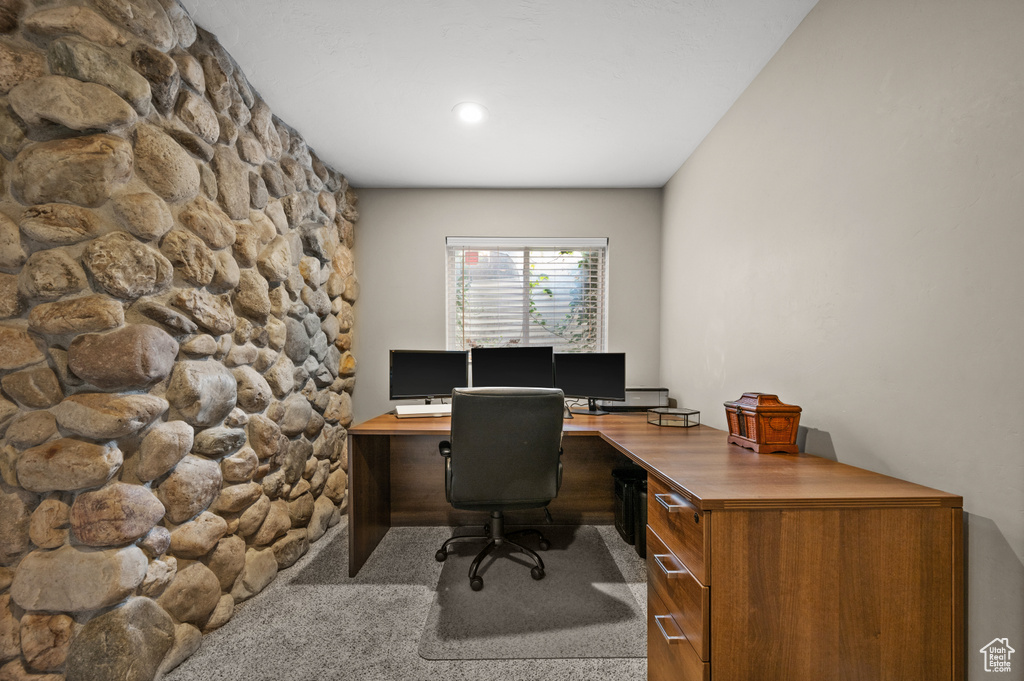Carpeted office space featuring built in desk