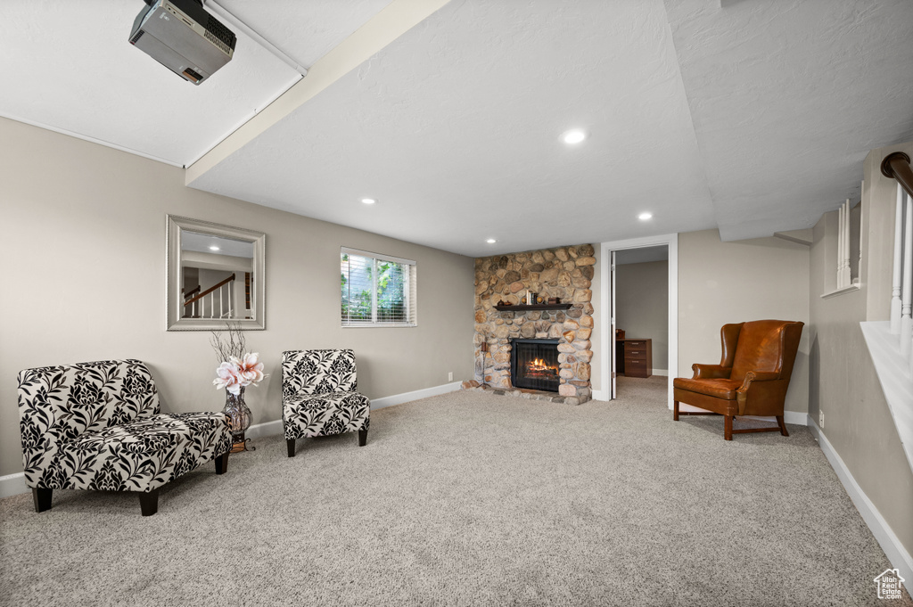 Sitting room with carpet and a stone fireplace