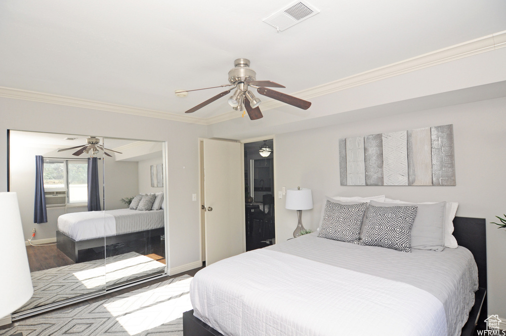 Bedroom with ornamental molding, wood-type flooring, and ceiling fan