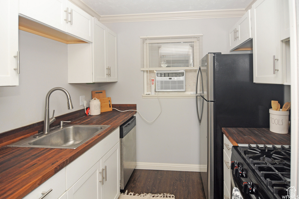 Kitchen featuring dark hardwood / wood-style floors, sink, white cabinetry, and butcher block counters