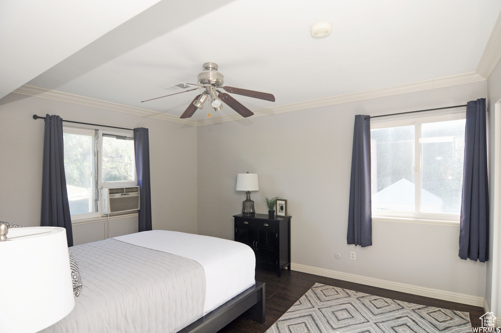 Bedroom with ceiling fan, crown molding, and dark hardwood / wood-style floors