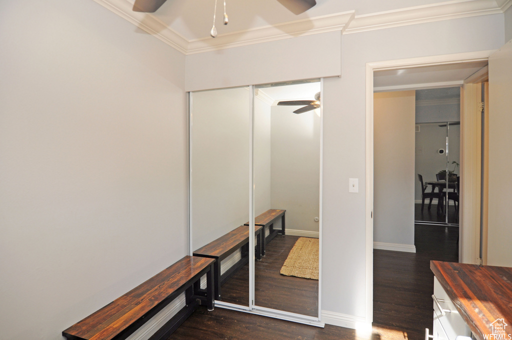 Interior space with dark hardwood / wood-style floors and ornamental molding