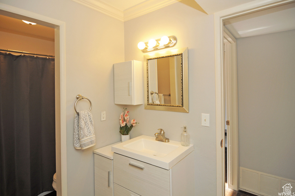 Bathroom featuring crown molding, toilet, and vanity