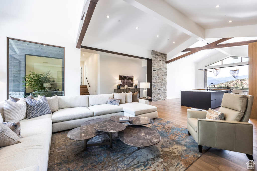 Living room featuring lofted ceiling with beams, dark wood-type flooring, and sink