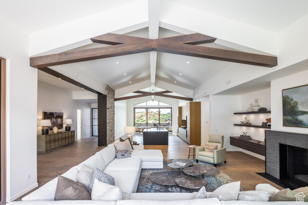 Living room featuring lofted ceiling with beams, dark hardwood / wood-style flooring, and a fireplace