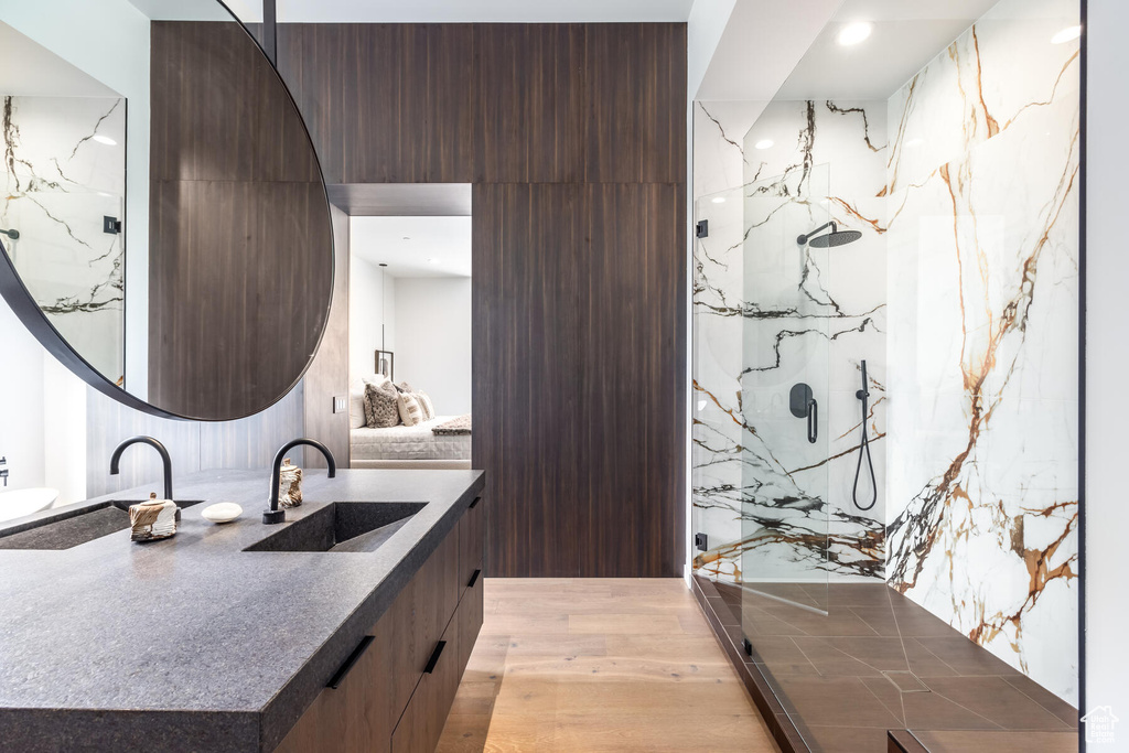 Bathroom with a shower, vanity, and wood-type flooring