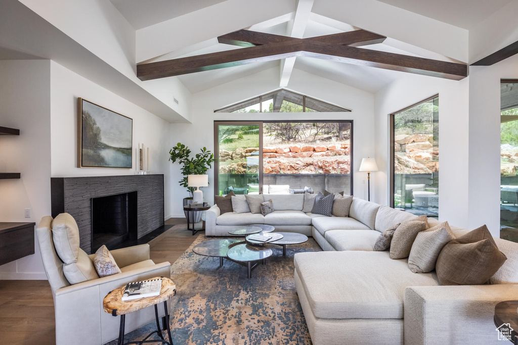 Living room featuring dark hardwood / wood-style floors and vaulted ceiling with beams