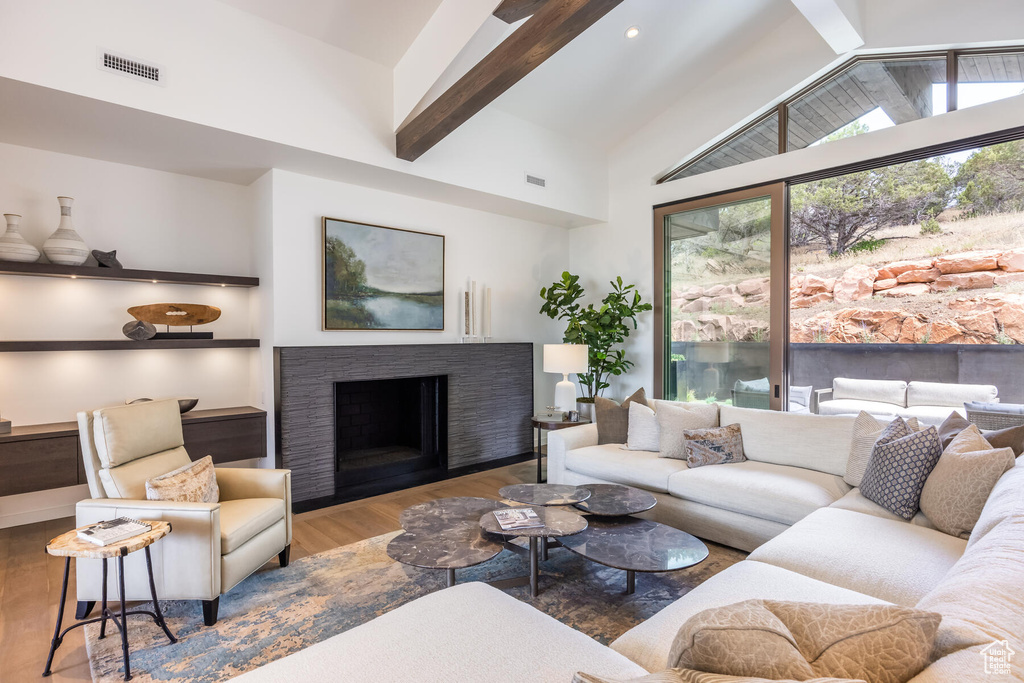 Living room featuring hardwood / wood-style floors, high vaulted ceiling, and beam ceiling