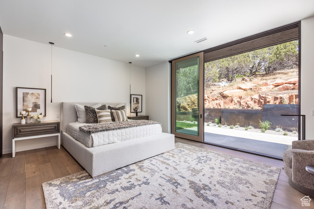 Bedroom with hardwood / wood-style floors and access to outside