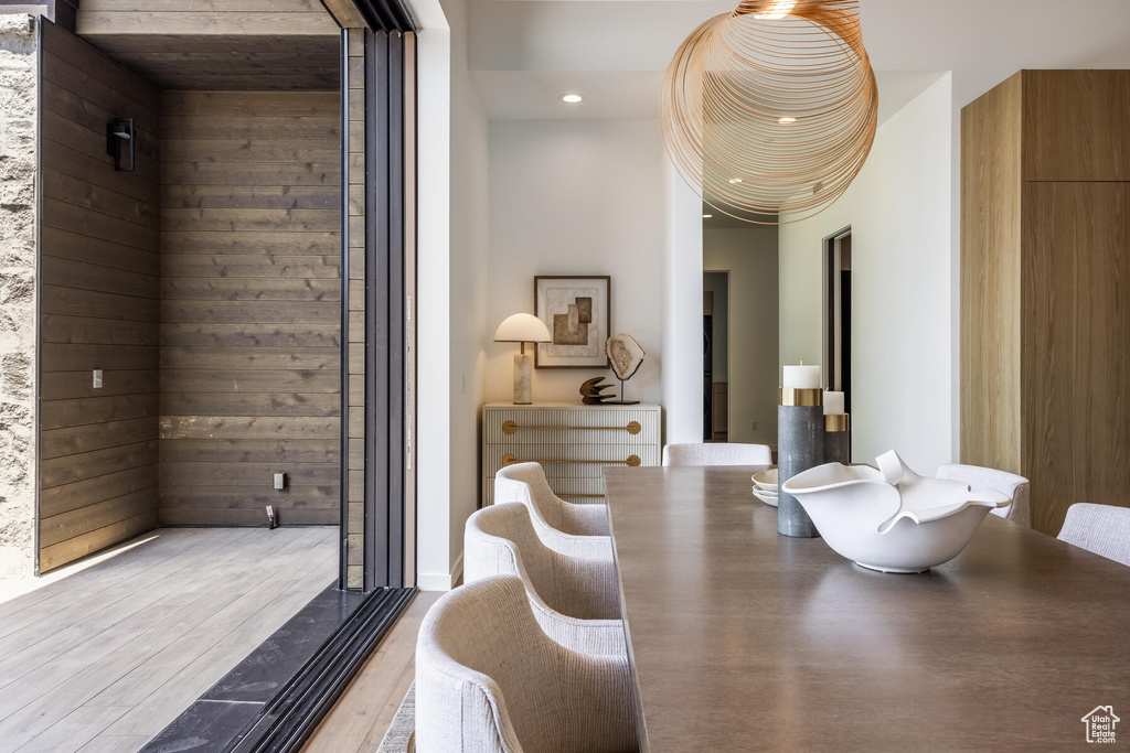 Dining room with wood walls and hardwood / wood-style floors