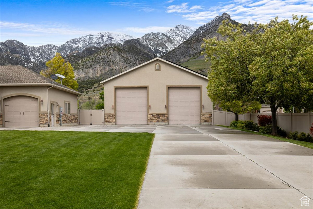 Ranch-style home featuring a mountain view and a front lawn