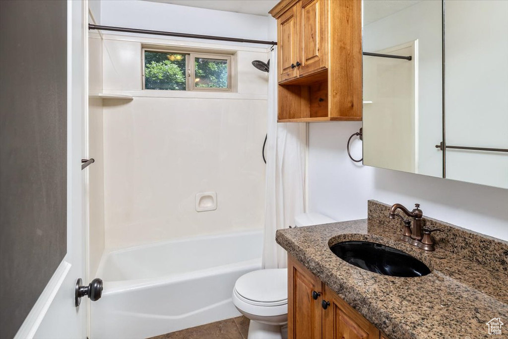 Full bathroom featuring bathing tub / shower combination, vanity, toilet, and tile floors