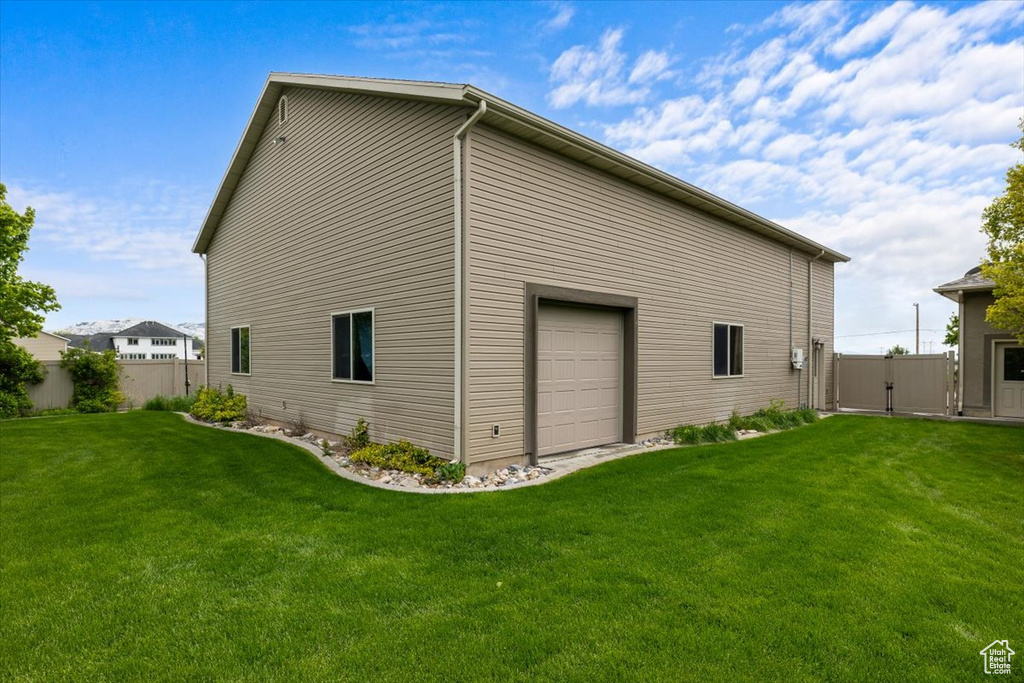 View of side of property featuring a yard and a garage