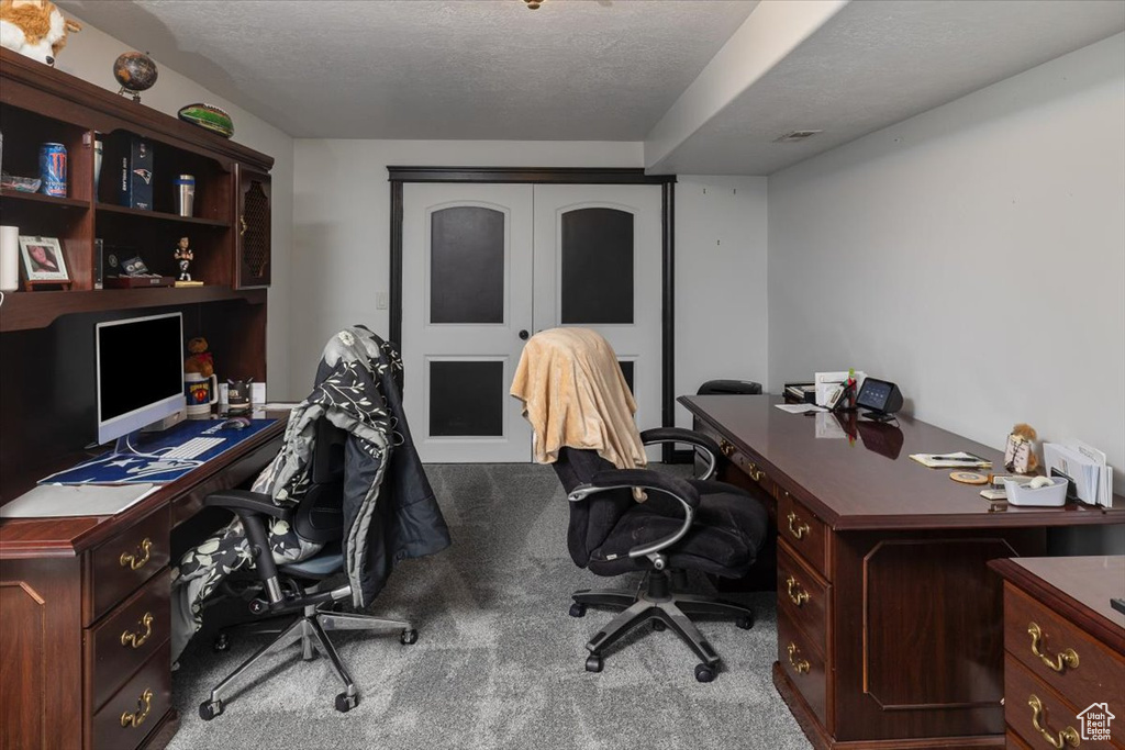 Office space featuring a textured ceiling and carpet flooring