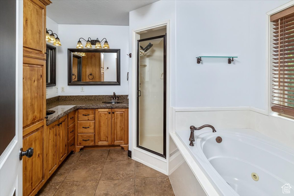 Bathroom with separate shower and tub, vanity, and tile floors