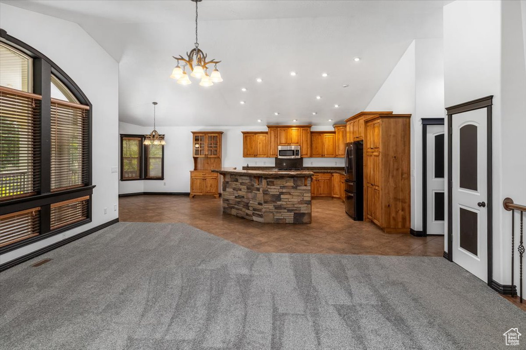 Kitchen featuring black fridge, a center island, and carpet flooring