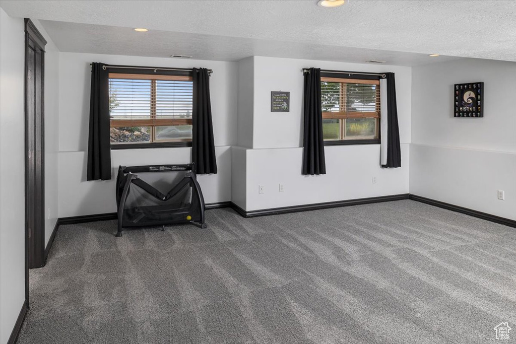 Carpeted empty room featuring a textured ceiling