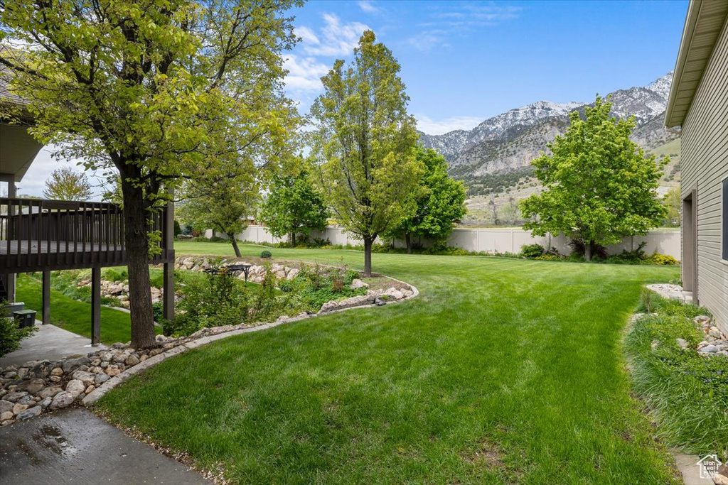 View of yard with a deck with mountain view