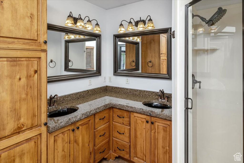 Bathroom featuring a shower with shower door and double vanity