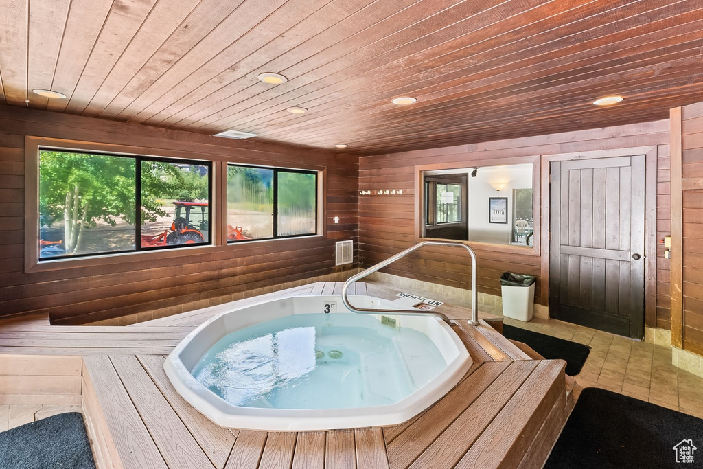 Misc room with light tile floors, wood ceiling, wood walls, and a jacuzzi