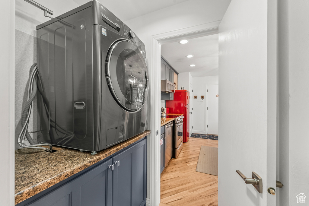 Laundry room with washer / clothes dryer and light wood-type flooring