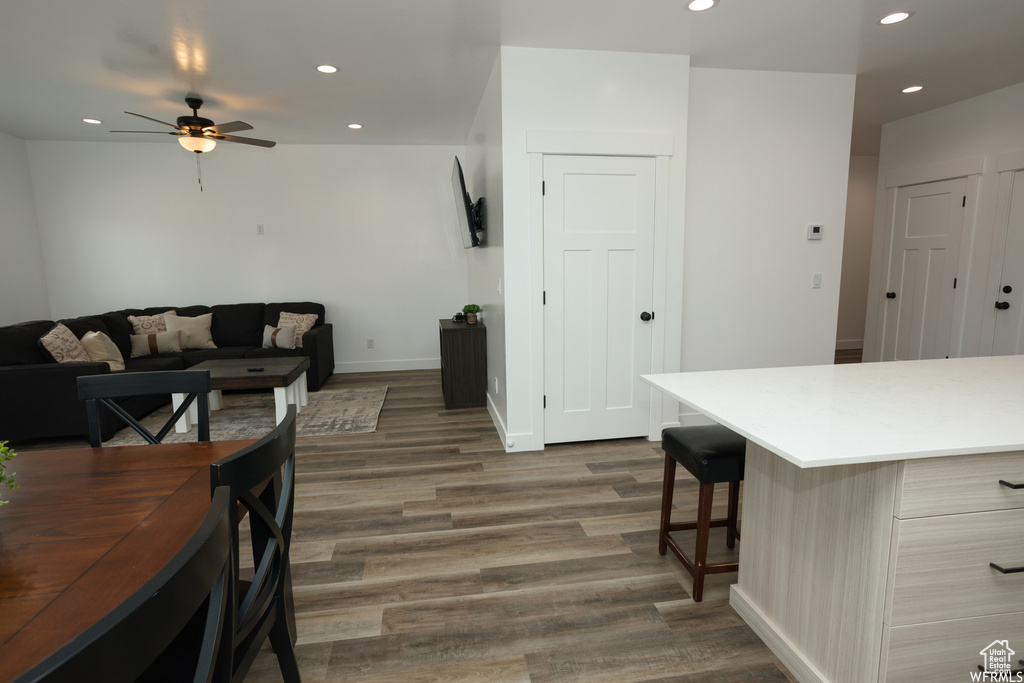 Interior space with ceiling fan and dark wood-type flooring