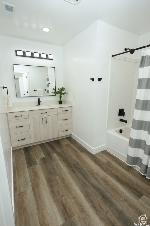 Bathroom with vanity, hardwood / wood-style flooring, and shower / tub combo with curtain