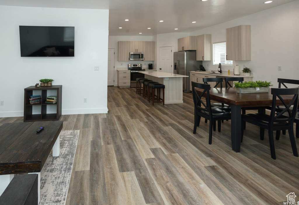 Dining area with hardwood / wood-style floors and sink