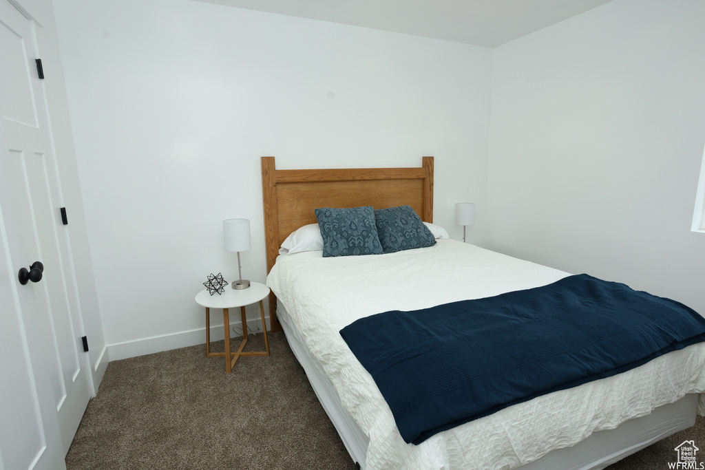 Bedroom featuring dark colored carpet