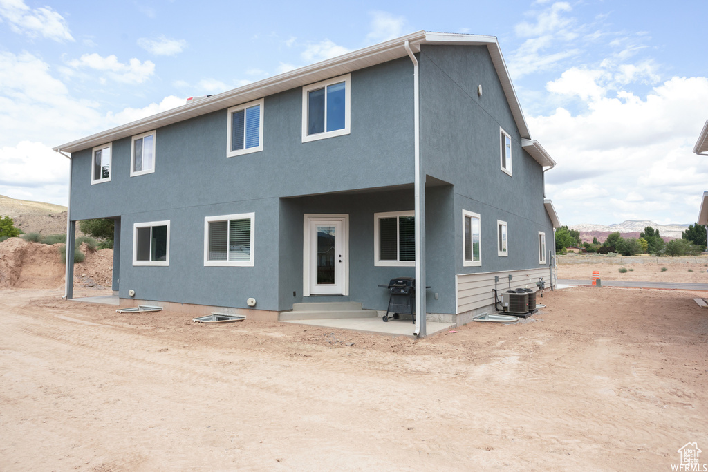 View of front of house featuring central AC and a patio area