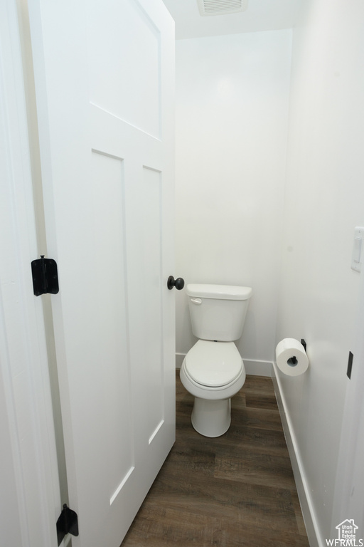 Bathroom featuring wood-type flooring and toilet