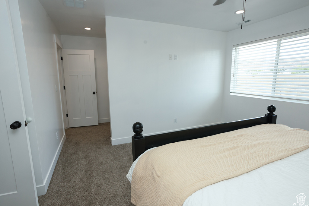 Bedroom with dark colored carpet and ceiling fan