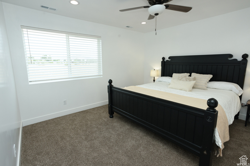 Bedroom featuring ceiling fan and dark carpet