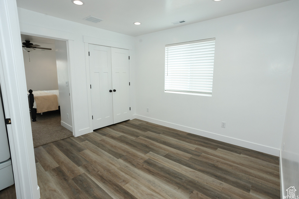 Unfurnished bedroom with dark hardwood / wood-style flooring and a closet