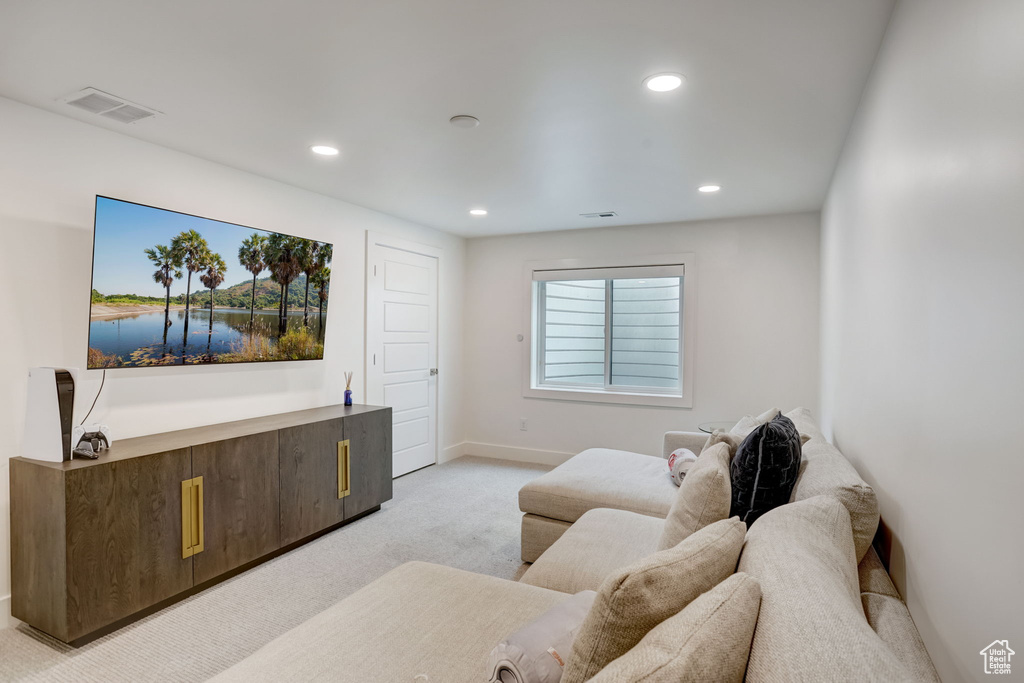 Living room featuring light colored carpet, a water view, and a healthy amount of sunlight