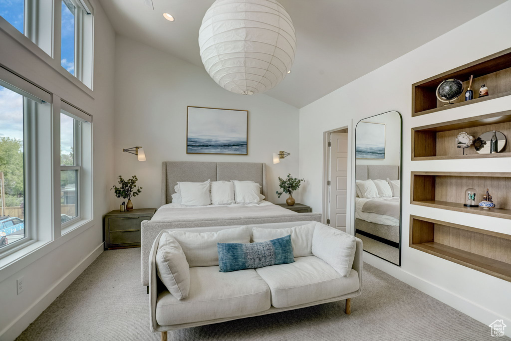 Bedroom featuring lofted ceiling, multiple windows, and carpet floors