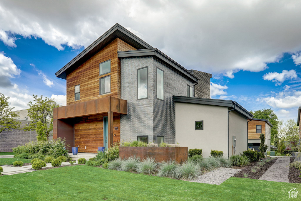 Exterior space with a front lawn and a balcony