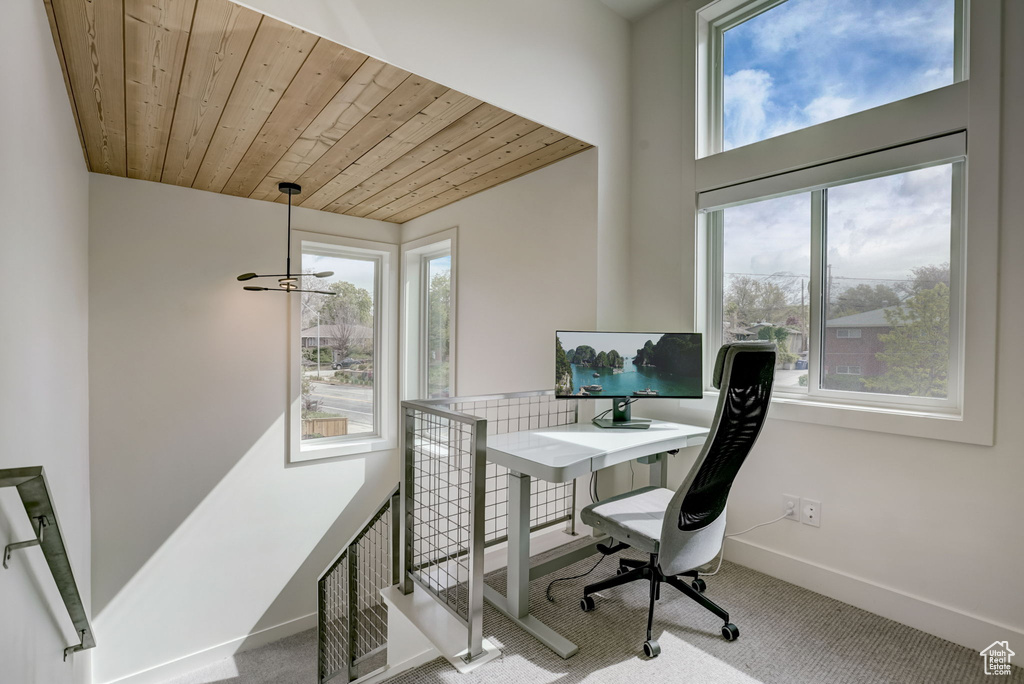 Home office featuring wooden ceiling, carpet floors, and a notable chandelier