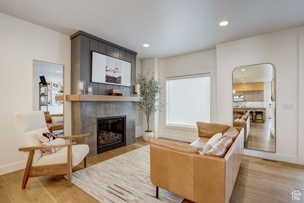 Living room with light hardwood / wood-style flooring and a fireplace